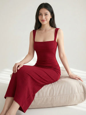 Side sitting pose of SwanClad Red Solid Sleeveless Midi Bodycon Dress showcasing fitted waist and smooth drape
